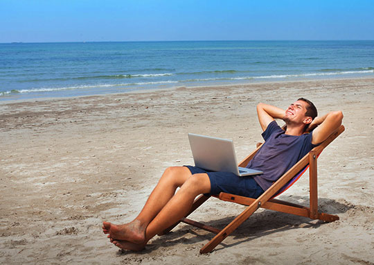 Man in lounge chair on the beach by ocean